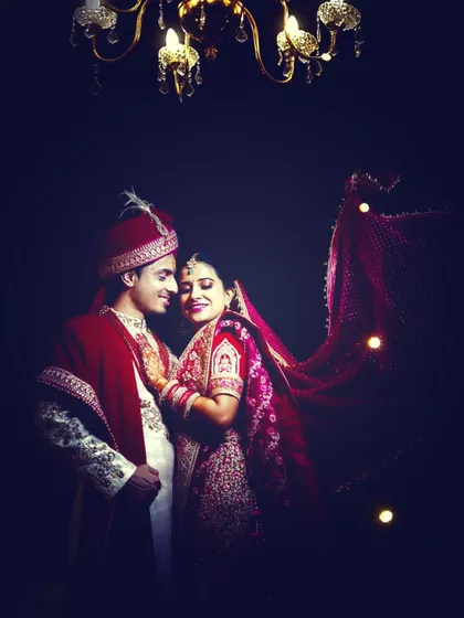 A royal-looking indoor wedding portrait, using dramatic lighting to create a rich and elegant photograph.
