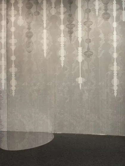 The 'AION' wall from the 'Silver Escapade' installation, where text and pattern merge. The space is designed as a walkthrough that blurs the distinct boundaries of past, present, and future through a play of forms and reflective surfaces.