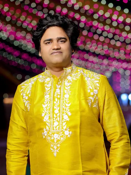 A portrait of a guest looking sharp in a yellow embroidered kurta at a Haldi ceremony.
