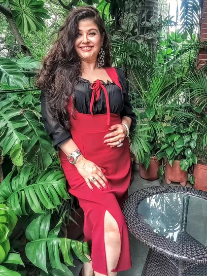 My Autumn collection is all about statement pieces. Here I'm wearing a red slit dress layered with a black chiffon top, showcasing how you can play with colors and layers to create a unique look.