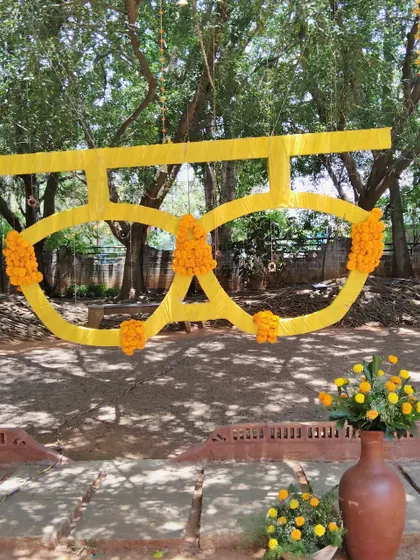 A fun and quirky prop for a Haldi or Mehendi: oversized sunglasses made of yellow fabric and marigolds.
