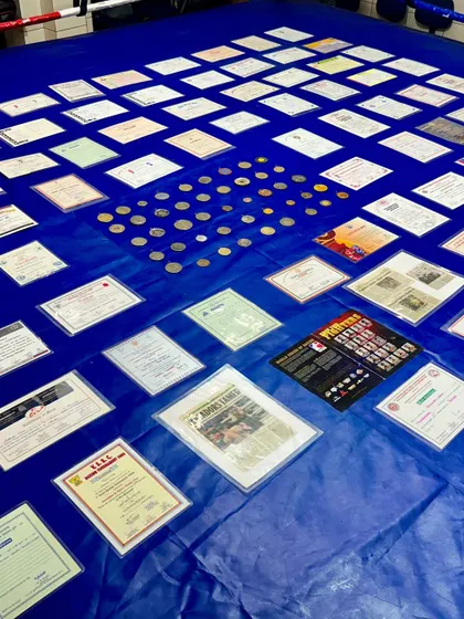 A closer look at the hardware. These are not just medals and papers. They represent years of sweat, discipline, and the will to win against all odds.