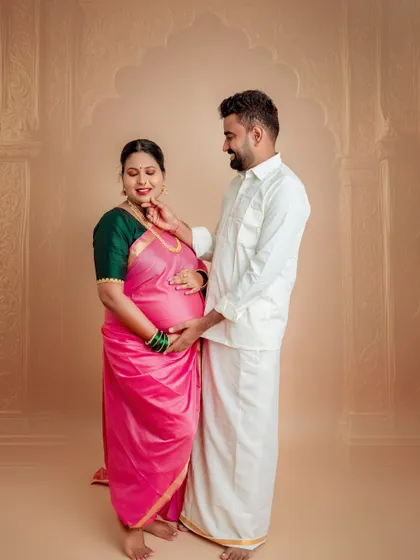 A tender moment between the couple, dressed in traditional attire. His gentle touch and her serene smile make this a heartwarming portrait of shared love and anticipation.
