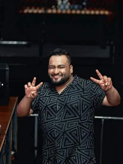 Spreading good vibes from the DJ booth. A smile and a peace sign can go a long way in setting a positive tone for the night.