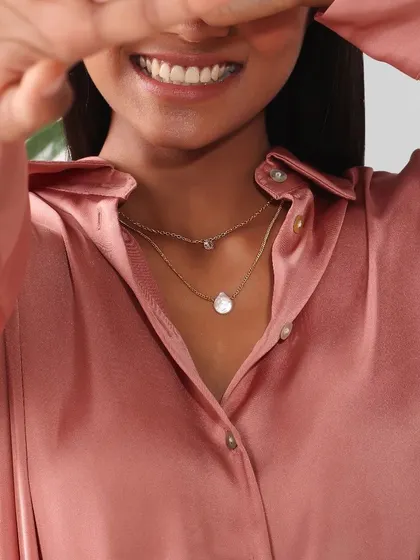 For jewelry and beauty campaigns, the focus is on clean, detailed close-ups. This shot highlights a delicate layered necklace while capturing a natural, happy expression, making it perfect for both commercial accessory brands and a model's beauty portfolio.