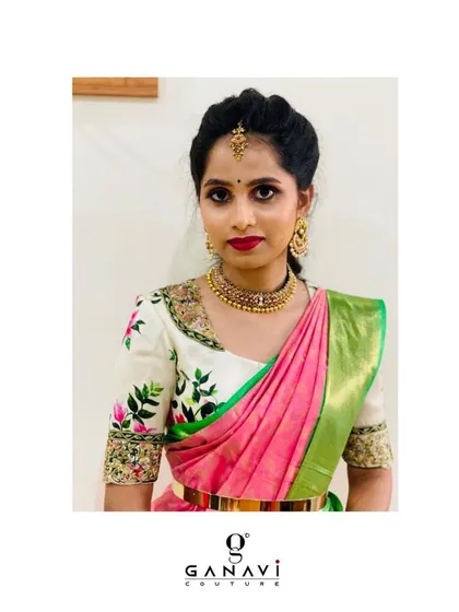Anusha in a delicately embroidered ensemble. Her ivory blouse features beautiful, hand-embroidered floral motifs, adding a touch of spring-like freshness to her pink and green saree.