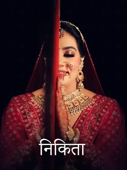 A creative portrait of bride Nikita, her face framed by a red line, drawing focus to her prayerful hands.