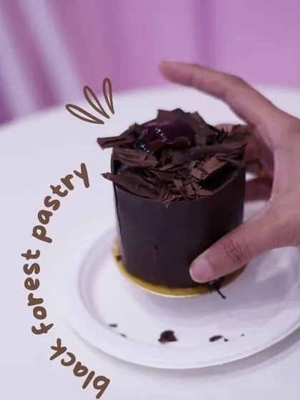 A close-up of our individual eggless Black Forest pastry. It's a mini version of the classic, with layers of chocolate, cream, and cherry, all wrapped in a chocolate shell.