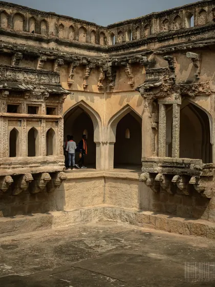 The Queen's Bath in Hampi, showcasing the intricate archways and design. I focus on details that tell the story of the structure's history and purpose.