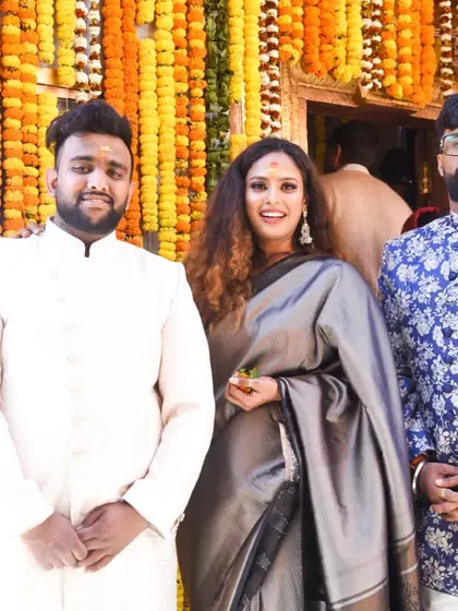 Attending my sister's wedding with my brothers. I opted for a sophisticated grey saree, which stands out beautifully against the vibrant marigold decor. This is a great Indian wedding guest style inspiration.