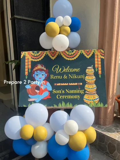 A close-up of the personalized welcome sign for a son's naming ceremony. The sign features a cute illustration of Little Krishna, setting the theme right from the entrance.