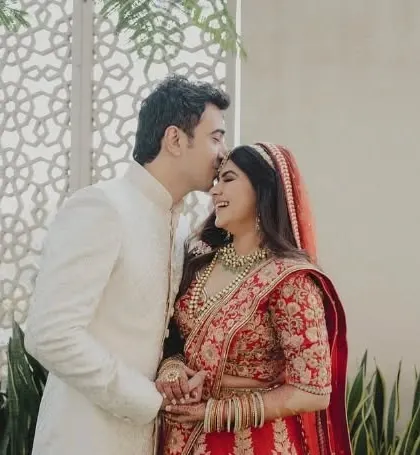 The groom gives his bride a sweet kiss on the forehead, a moment of pure love and tenderness.