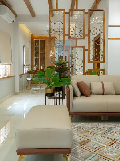 A decorative wooden partition with intricate jali work separates the living and dining areas. This element adds a traditional Indian touch while allowing light and sightlines to pass through, maintaining an open feel.