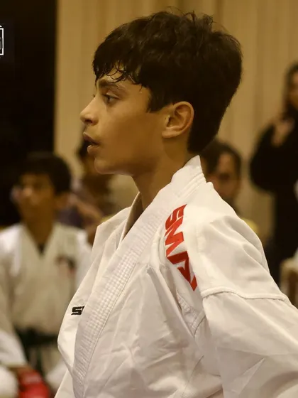 A young competitor, poised and ready. This portrait captures the quiet confidence of a student waiting for his match to begin.