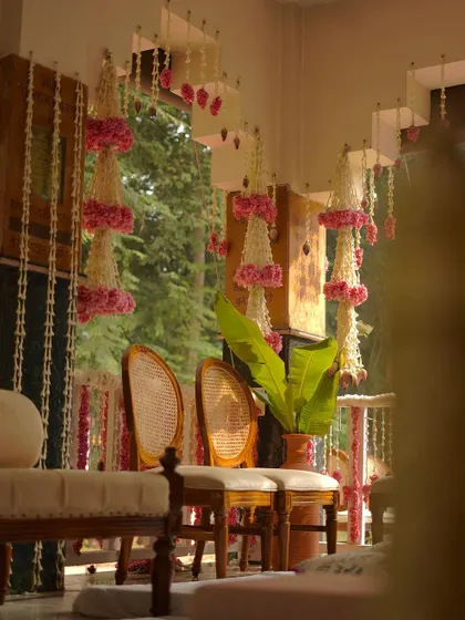 A quiet corner of the event space, showing the elegant seating arrangement and the beautiful hanging floral decor, bathed in natural light.