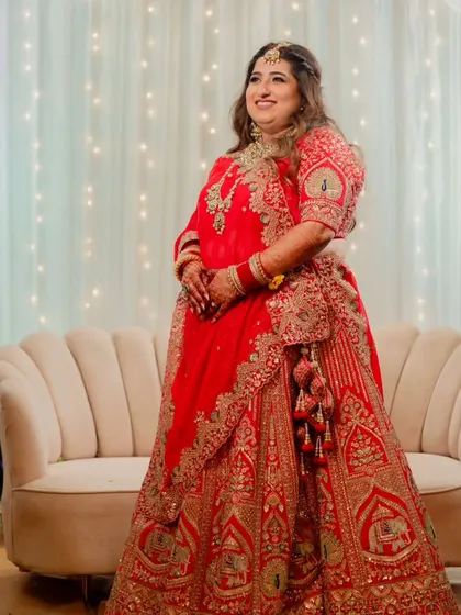 A beautiful full-length shot of the bride in her reception lehenga. The entire look is cohesive, from the flowing hair to the detailed outfit.