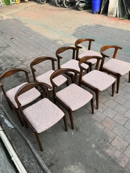 A set of eight mid-century modern dining chairs, ready for delivery. The curved wooden backrest and upholstered seat offer ergonomic comfort, making them an excellent choice for restaurants that want both style and practicality.