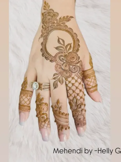 A modern take on a full back-hand design, this piece features a circular frame with a floral vine emerging from it. The use of negative space and net patterns on the fingers adds a contemporary touch.