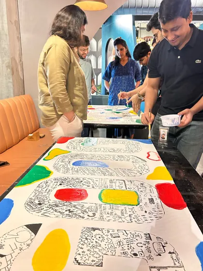 The moment of truth! The Google team adds vibrant brand colors around their completed doodle mural. This step brings the entire piece together and adds a final pop of energy.