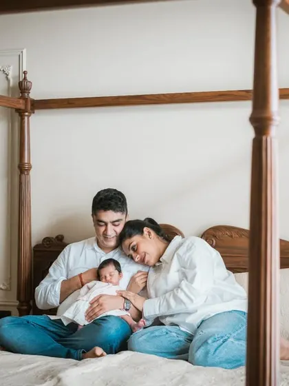 The new family, all together in their own space. This lifestyle portrait on the bed feels natural and relaxed, a true snapshot of their new life as a family of three.