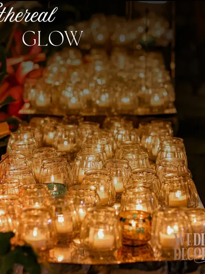 A sea of candles in glass votives, creating a powerful statement of warmth and light. This kind of massed candle installation is perfect for defining a space or creating a dramatic focal point.