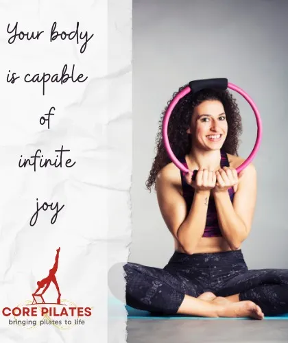 Your body is capable of infinite joy. A client smiles while holding the magic circle, capturing the positive and encouraging atmosphere of our studio.
