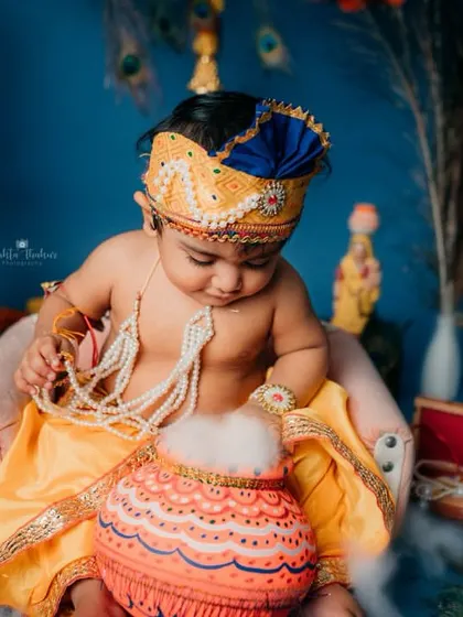 Caught in the act with the pot of butter. This is a classic and playful pose for a Janmashtami baby photoshoot.