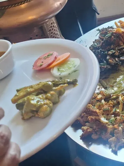 A guest's plate at a naming ceremony, featuring a selection of our vegetarian dishes. I always offer a variety, including classic vegetable preparations, salads, and pickles.