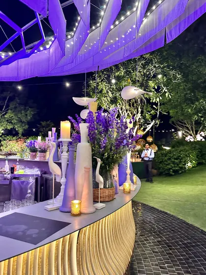 Our circular bar lit up in a lovely lavender hue, with matching floral arrangements, for a themed cocktail evening.