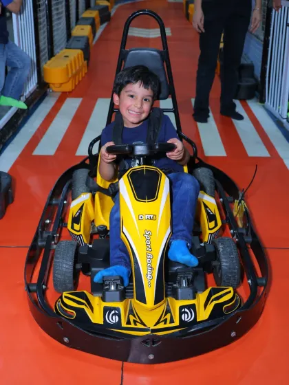 All smiles in the driver's seat! Our yellow go-kart is another popular choice for kids ready to experience the thrill of the race.