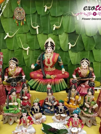 A traditional South Indian Golu display for Navratri, set against a backdrop of fresh banana leaves. This arrangement showcases a beautiful collection of dolls depicting various deities and scenes.