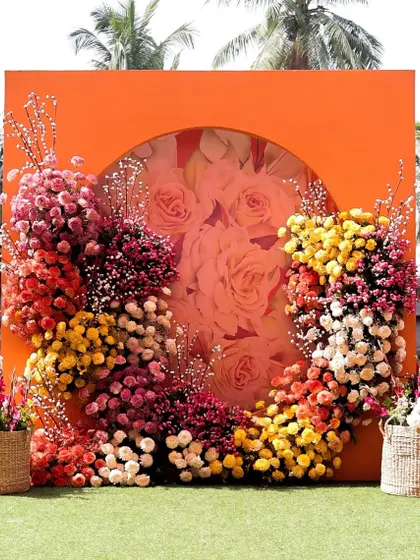 A stunning floral photo wall with a circular cutout, crafted from a spectrum of colorful flowers for a dramatic and beautiful installation.