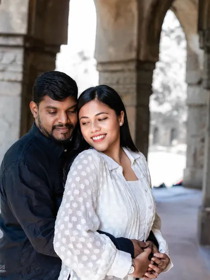 A classic portrait within the stone archways of a Delhi monument, highlighting the couple's elegant pose and the beautiful, historic setting.