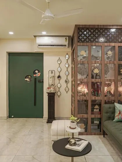 A view of the living room from image 22, focusing on the green sofa and hand-painted partition.