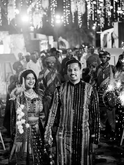 A classic black and white shot of the couple's sparkler entrance, creating a timeless and magical feel.