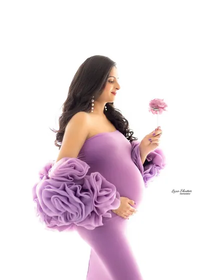 A simple prop like a single flower can add a delicate and meaningful touch to your portrait, echoing the color of the gown and the theme of new life.