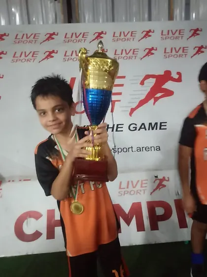 One of our youngest champions holding the trophy after the U9 Junior League win.