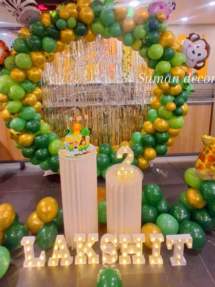 A closer view of the jungle party decor, showing the animal-themed cake on the plinth and the detailed balloon work.