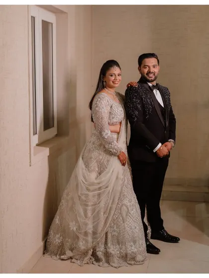 A classic reception portrait of Shreya and Rakshit, looking elegant in their coordinated outfits.