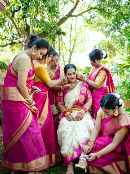 The bride's squad helps her get ready, a beautiful candid moment of friendship and support on her wedding day.