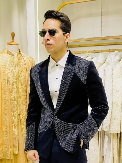 The full look of the navy velvet embroidered tuxedo. Paired with a crisp white shirt, it creates a powerful silhouette that balances intricate detail with classic formalwear structure.