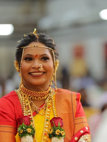 A happy bride during her Vidhi ceremony. The yellow and red saree combination is vibrant, and her makeup is fresh and glowing.