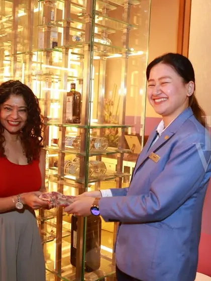 A representative from our venue partner, Vivanta, presenting a gift to one of our attendees during the Women's Day event.