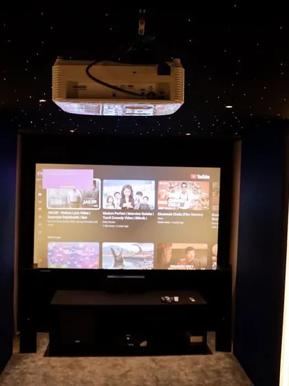 The ceiling-mounted projector and starlit sky effect add a touch of luxury to this otherwise minimalist and compact theater room.