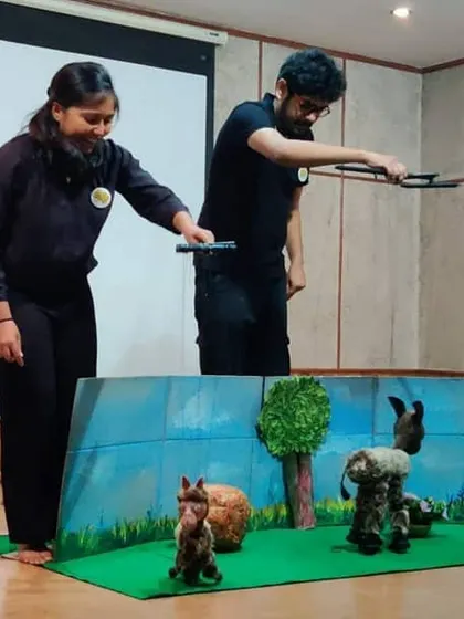 A performance in progress. You can see the puppeteers working together to control the characters on the mini stage.