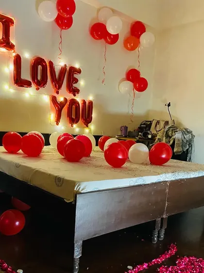 Another angle of the "I Love You" room decoration, showing the balloons and rose petals on the floor.