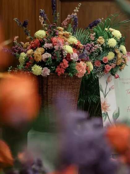 A floral basket and welcome sign being arranged at the entrance of the venue.