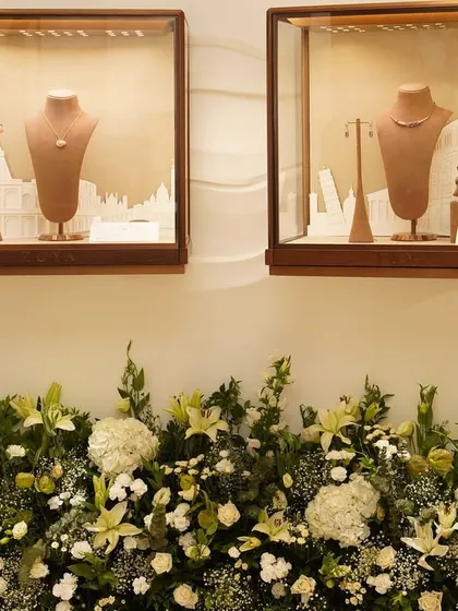 Floral arrangements placed below the jewelry displays at the Zoya store launch, enhancing the beauty of the collection without overpowering it.