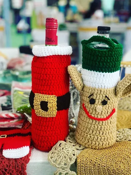 A Santa and reindeer bottle cover, perfect for gifting wine during the Christmas season.