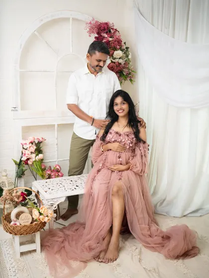 A beautiful portrait of the couple in a light and airy setting. The soft pink gown and floral decor create a romantic and gentle atmosphere.